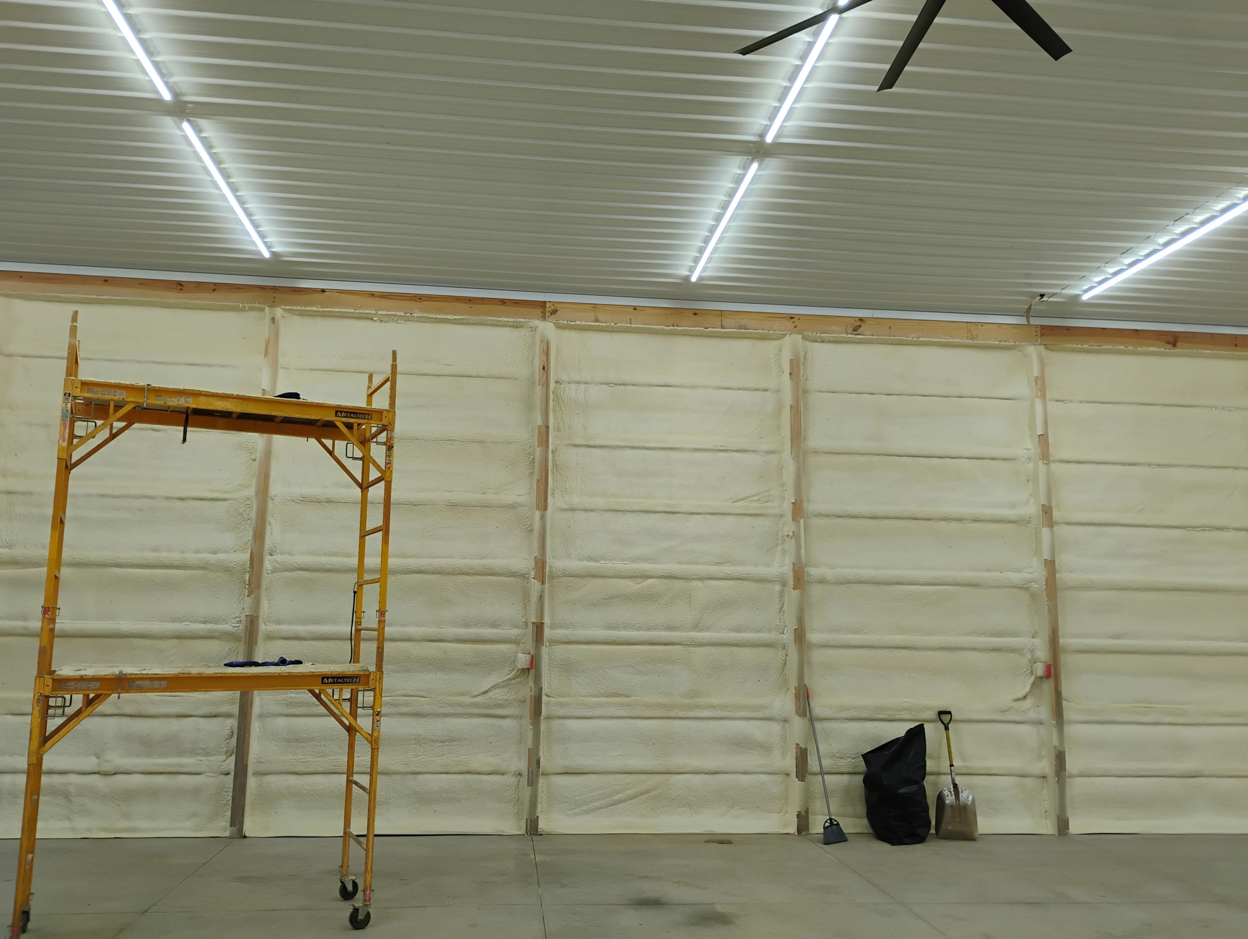 Spray foam installer working in a framed space